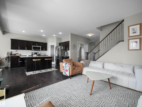 Open-concept living space featuring dark wood-finish flooring - 3247 15 Avenue Nw, Edmonton, AB 