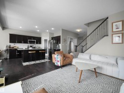 Open-concept living space featuring dark wood-finish flooring - 