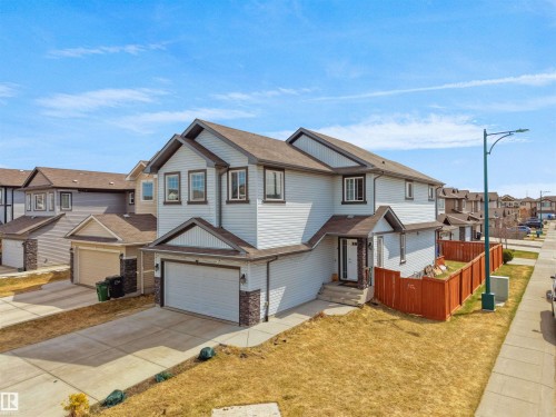 Two-story residence featuring light-colored siding and dark trim accents - 3247 15 Avenue Nw, Edmonton, AB 
