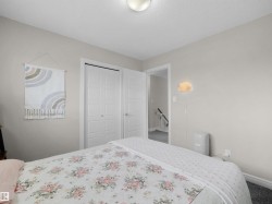 Bedroom featuring light gray wall paint, two white bi-fold closet doors, and recessed lighting - 