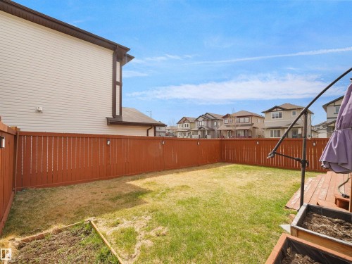 Expansive backyard with a manicured lawn, full privacy fencing, and wood deck - 3247 15 Avenue Nw, Edmonton, AB 