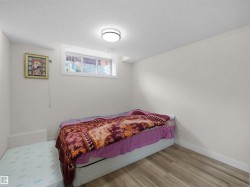 Interior room featuring light wood-finish flooring, white walls, and a white ceiling with a flush-mount circular light fixture - 