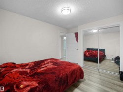 Bedroom featuring light-toned wood-finish flooring and a flat-panel door - 