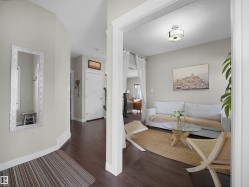 Hallway entry with dark wood-finish flooring and light grey wall paint - 