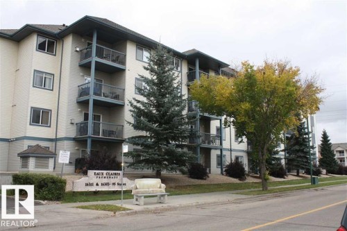 Multi-story condominium building featuring light-colored siding with dark trim accents - 424 16303 95 Street, Edmonton, AB - Outdoor With Balcony