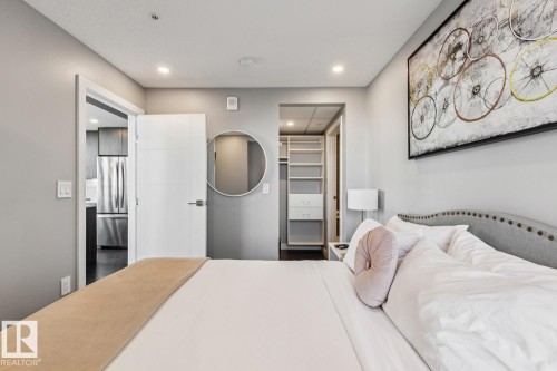 Bedroom featuring a built-in closet system with shelving and drawers, recessed lighting, and a modern white door - 3302 10180 103 Street, Edmonton, AB - Indoor Photo Showing Bedroom