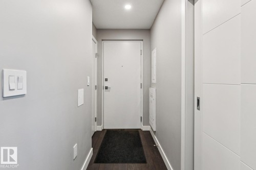 Entryway featuring wood-finish flooring, recessed lighting, and a modern white panel door - 3302 10180 103 Street, Edmonton, AB - Indoor Photo Showing Other Room