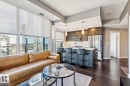 Open-concept living space featuring expansive windows with roller shades, dark wood-finish flooring, and a contemporary kitchen - 3302 10180 103 Street, Edmonton, AB  - Indoor Photo Showing Other Room 