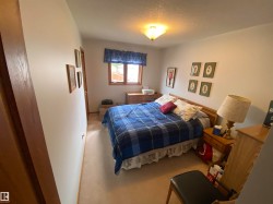 Carpeted room with a ceiling-mounted light fixture, a window with a valance, and light-toned wall paint - 