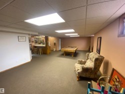 Finished lower level featuring a built-in wet bar, recessed lighting, and carpet flooring - 