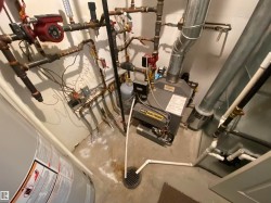 Utility space featuring a water heater, boiler system, and floor drain - 