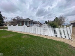 White picket fence defining the property perimeter with a gravel border - 