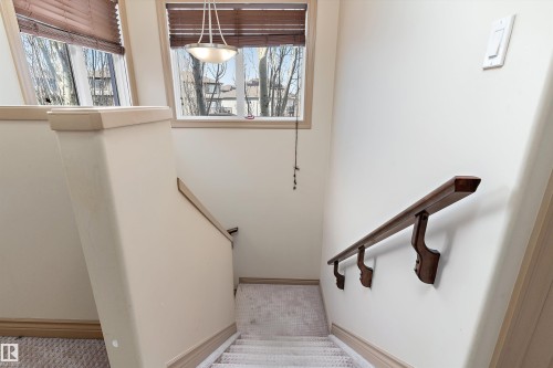 Carpeted staircase featuring a wood handrail with decorative brackets - 23 3103 Hilton Drive, Edmonton, AB - Indoor Photo Showing Other Room