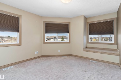 Carpeted room with three windows featuring light-colored trim and blinds - 23 3103 Hilton Drive, Edmonton, AB - Indoor Photo Showing Other Room