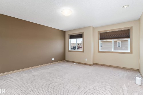 Carpeted room featuring a neutral color palette, two windows with blinds, a flush mount ceiling light, and recessed lighting - 23 3103 Hilton Drive, Edmonton, AB - Indoor Photo Showing Other Room