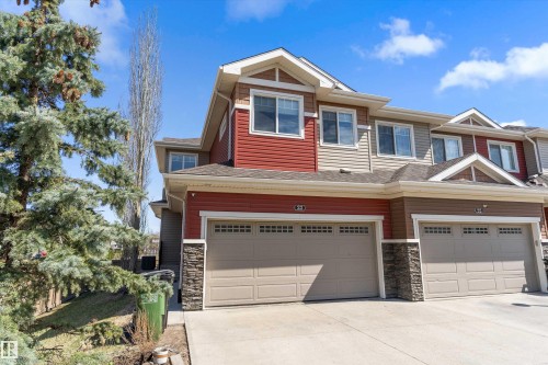 Townhome exterior featuring horizontal siding, stacked stone accents, and a two-car garage - 23 3103 Hilton Drive, Edmonton, AB - Outdoor With Facade