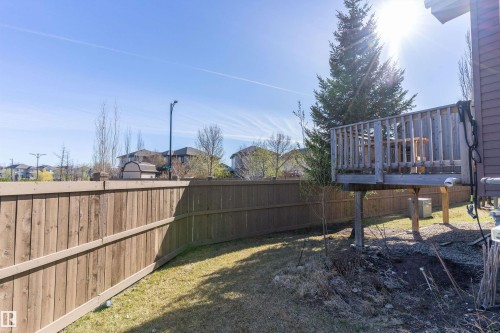 Backyard area featuring a wood fence, green lawn space, and an elevated wood deck - 23 3103 Hilton Drive, Edmonton, AB - Outdoor With Deck Patio Veranda