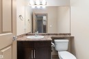 Bathroom featuring a dark wood-finish vanity with a white oval sink, chrome faucet, and a granite-look countertop - 23 3103 Hilton Drive, Edmonton, AB  - Indoor Photo Showing Bathroom 