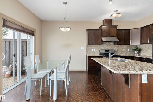 Kitchen and dining area featuring wood-finish flooring - 23 3103 Hilton Drive, Edmonton, AB - Indoor