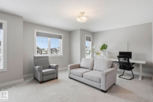 Living room featuring carpet flooring and a textured ceiling - 1915 77 Street, Edmonton, AB - Indoor Photo Showing Living Room