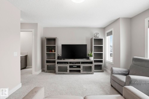 Living room featuring light colored carpet and a textured ceiling - 1915 77 Street, Edmonton, AB - Indoor Photo Showing Living Room