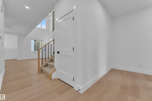 Interior entryway featuring light wood-finish flooring, white walls, and contemporary baseboards - 6226 45 Avenue, Beaumont, AB - Indoor Photo Showing Other Room