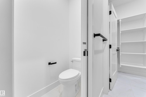 Dedicated water closet featuring a contemporary toilet, matte black hardware, and crisp white walls - 6226 45 Avenue, Beaumont, AB - Indoor Photo Showing Bathroom