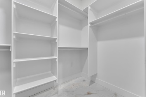 White built-in shelving and hanging rods offer ample storage - 6226 45 Avenue, Beaumont, AB - Indoor With Storage