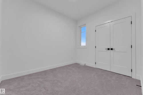 Neutral-toned carpeting paired with crisp white walls - 6226 45 Avenue, Beaumont, AB - Indoor Photo Showing Other Room