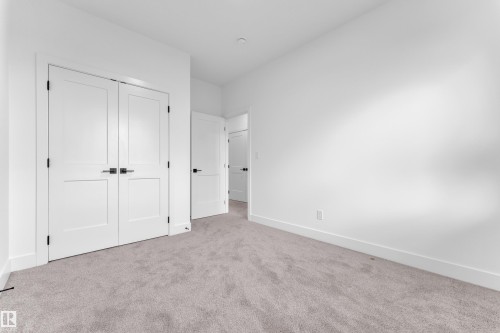 Bedroom featuring soft gray carpeting, white walls, and bright white baseboards - 6226 45 Avenue, Beaumont, AB - Indoor Photo Showing Other Room