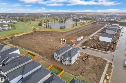 Developing residential area featuring new construction, a paved street, and proximity to a water feature and green space - 6226 45 Avenue, Beaumont, AB - Outdoor With View