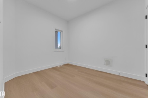 Bright interior space featuring light wood-finish flooring, white walls, and a single window providing natural illumination - 6226 45 Avenue, Beaumont, AB - Indoor Photo Showing Other Room