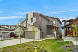 Contemporary multi-level residence featuring a gray and tan stucco exterior with dark wood-look siding accents - 