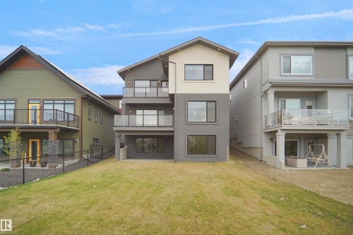 Contemporary multi-level exterior with a walk-out basement, multiple balconies featuring glass railings, and a tiered design - 162 Edgewater Circle, Leduc, AB - Outdoor With Balcony With Facade