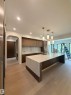 Kitchen featuring a waterfall island with a stone countertop, wood-finish cabinetry, integrated sink, and pendant lighting - 14702 Park Drive, Edmonton, AB  - Indoor Photo Showing Kitchen 