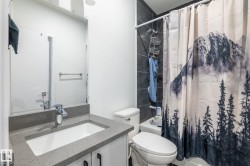 Modern bathroom featuring a single vanity with a light gray countertop and undermount sink - 