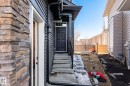 Front entry featuring a dark paneled door, concrete steps, and a black handrail - 6607 50A Avenue, Beaumont, AB  - Outdoor 