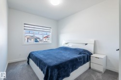 Bright room featuring a window with horizontal blinds, overhead lighting, and grey carpet flooring - 