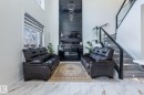 Two-story living area featuring a dramatic black stone-finish accent wall with integrated media console - 6607 50A Avenue, Beaumont, AB  - Indoor 
