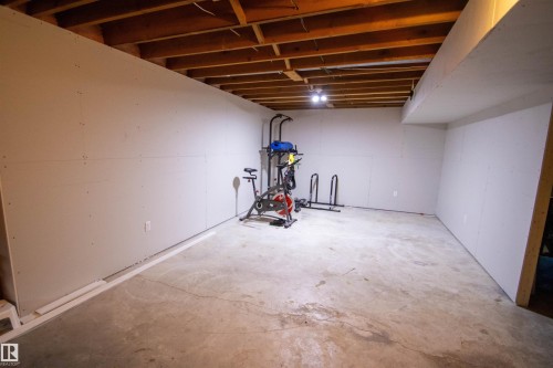 Unfinished lower level featuring exposed wood joists and concrete flooring - 5125 46 Ave, St. Paul Town, AB - Indoor Photo Showing Basement