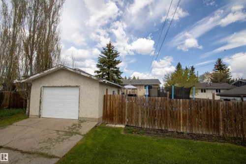 Detached garage with a white overhead door and concrete driveway - 5125 46 Ave, St. Paul Town, AB - Outdoor