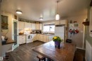 Kitchen with wood-finish flooring and white cabinetry - 5125 46 Ave, St. Paul Town, AB  - Indoor Photo Showing Kitchen With Double Sink 