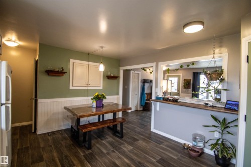 Wood-finish flooring throughout, complemented by a light green and white wainscoting wall treatment - 5125 46 Ave, St. Paul Town, AB - Indoor Photo Showing Dining Room