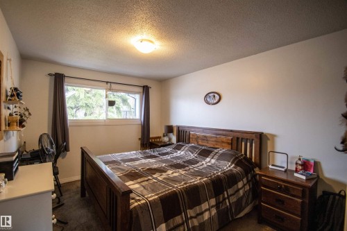 Bedroom featuring light-colored walls and dark wood-finish flooring - 5125 46 Ave, St. Paul Town, AB - Indoor Photo Showing Bedroom