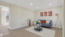 Spacious living area featuring light-toned walls, recessed lighting, and light wood-finish flooring - 