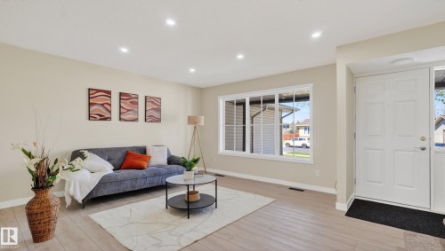 Light wood-finish flooring extending from the entryway - 14125 30 Street, Edmonton, AB - Indoor Photo Showing Living Room