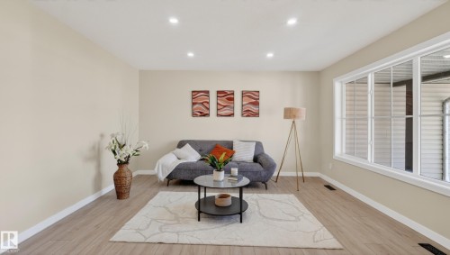Open-concept living space with light neutral wall tones and wood-finish flooring - 14125 30 Street, Edmonton, AB - Indoor