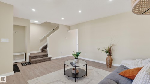 Contemporary living area featuring wood-finish flooring, recessed lighting, and a neutral color palette - 14125 30 Street, Edmonton, AB - Indoor