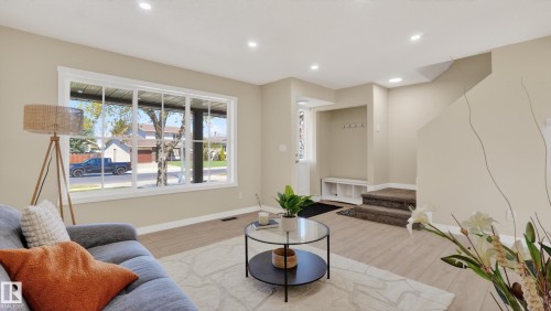 Spacious living area featuring a large picture window, recessed lighting, light wood-finish flooring, and a built-in entryway bench with coat hooks - 14125 30 Street, Edmonton, AB - Indoor