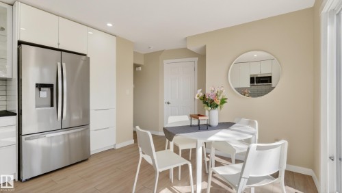 Kitchen and dining area featuring light-tone wood-finish flooring - 14125 30 Street, Edmonton, AB - Indoor Photo Showing Dining Room